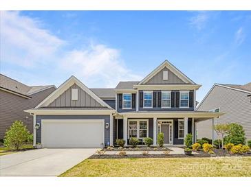 Charming two-story home with a well-manicured lawn, inviting front porch, and attached two-car garage at 235 Boxelder Rd, Clover, SC 29710
