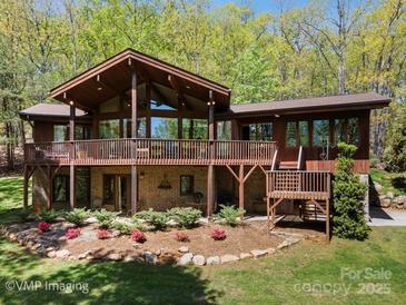 Stunning wood exterior with large windows and spacious deck surrounded by lush greenery at 3605 Ridgetop Rd, Sherrills Ford, NC 28673