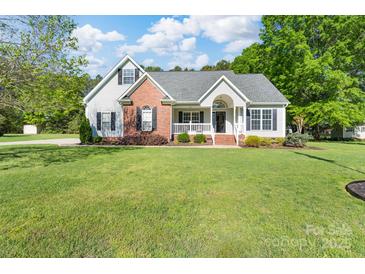 Inviting single-Gathering home showcasing manicured lawn, gray siding, and charming brick accents for classic curb appeal at 921 Snow Prince Ln, York, SC 29745