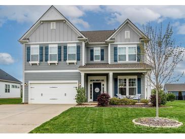 Beautiful two-story home with blue shutters, gray siding, and a well-manicured lawn at 10024 Fox Trotter Ln, Midland, NC 28107