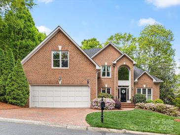 Charming brick home featuring a two-car garage, manicured lawn, and beautiful landscaping at 10626 Newberry Park Ln, Charlotte, NC 28277