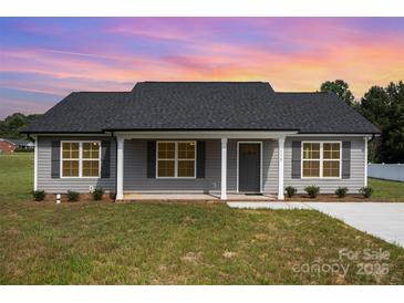 Charming single-story home featuring gray siding, a dark shingle roof, and a well-maintained front lawn at 115 Frances St, Salisbury, NC 28147