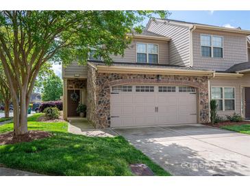 Charming townhome featuring a stone facade, two-car garage, and beautifully landscaped front yard at 2001 Cramer Place Ct, Cramerton, NC 28032