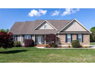 Charming home with a combination of stone and siding, manicured lawn, and inviting front porch at 234 Deal Estate Dr, China Grove, NC 28023