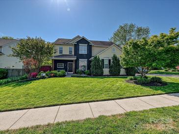 Charming two-story home featuring a well-maintained lawn and beautifully landscaped front yard with mature trees at 8140 Laurel Run Dr, Charlotte, NC 28269