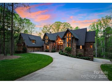 Stunning exterior of a multi-story home featuring a stone facade, timber accents, and a circular driveway at 10723 Green Heron Ct, Charlotte, NC 28278