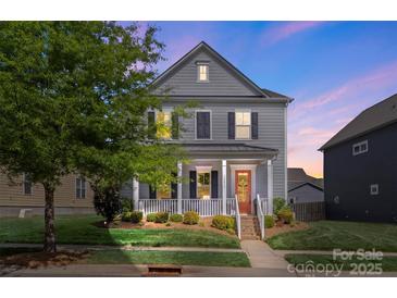 Charming two-story home featuring a welcoming front porch, landscaped lawn, and a classic design at 13813 Jacks Ln, Pineville, NC 28134