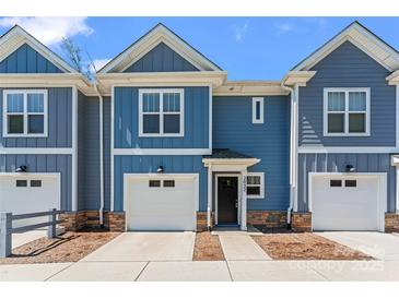 Charming townhome with blue siding, a one-car garage and an inviting black front door at 2032 Summey Ave, Charlotte, NC 28205