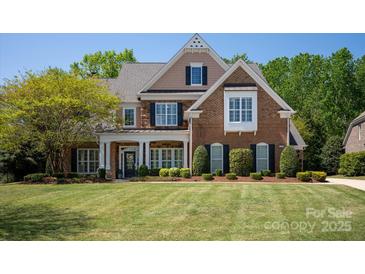 Beautiful brick and stone home with manicured lawn and mature trees provides stately curb appeal at 2610 Creek Manor Dr, Waxhaw, NC 28173