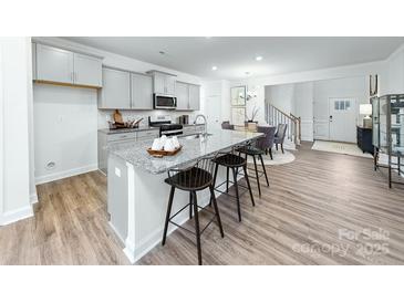 Modern kitchen boasts an island with a granite countertop and stainless steel appliances at 4240 Steel Way, Sherrills Ford, NC 28673