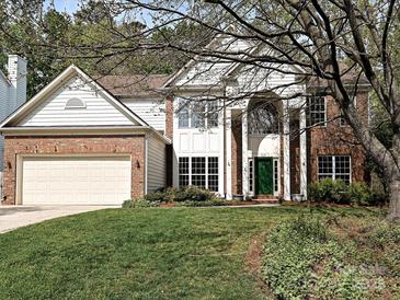 Charming two-story home featuring a brick facade, white columns, a green front door, and a well-maintained lawn at 6112 Swanston Dr, Charlotte, NC 28269