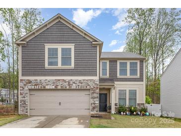 Charming two-story home features a stone and shingle facade, attached garage, and well-maintained landscaping at 710 Anglin Forest Way, Charlotte, NC 28214