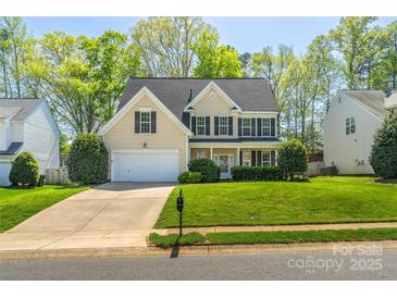 Charming two-story home with a manicured lawn, attached garage, and classic black shutters at 7353 Sedgebrook W Dr, Stanley, NC 28164