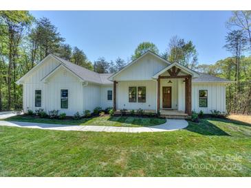 Charming single-story home featuring a beautifully landscaped front yard and inviting entrance with natural wood accents at 8225 Long Island Rd, Catawba, NC 28609