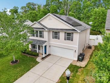 Two story home features solar panels, attached garage, light siding, and a well manicured lawn at 9612 Eagle Feathers Dr, Charlotte, NC 28214