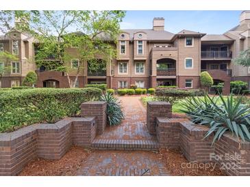 Beautiful multi-story condo building with brick pathway, manicured landscaping, and balcony views at 1109 E Morehead St # 22, Charlotte, NC 28204