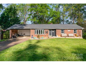 Charming brick home featuring a cozy front porch with benches and a well-maintained lawn at 1218 Donna Dr, Shelby, NC 28152