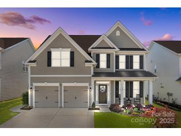 Charming two-story home with a manicured lawn, a two-car garage, and inviting front porch at 187 Longleaf Dr, Mooresville, NC 28117