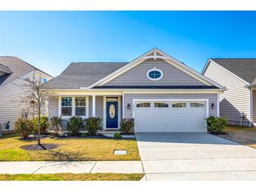 Charming single-story home featuring a well-manicured lawn, an attached two-car garage, and a stylish blue front door at 19010 Hawk Haven Ln, Charlotte, NC 28278