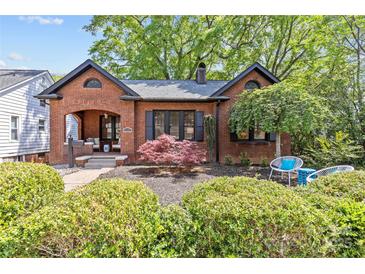 Charming brick home featuring manicured landscaping, black shutters, and inviting front porch at 2125 Kenilworth Ave, Charlotte, NC 28203