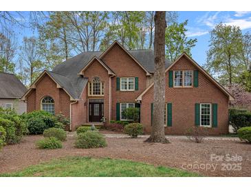 Charming red brick home with green shutters, mature landscaping, and a welcoming front entrance at 276 Greyfriars Rd, Mooresville, NC 28117