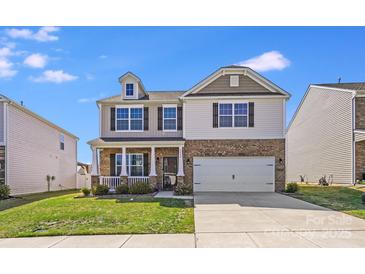 Charming two-story home featuring a covered porch, two-car garage, and well-maintained lawn on a sunny day at 3286 Shining Rock Sw St, Concord, NC 28027