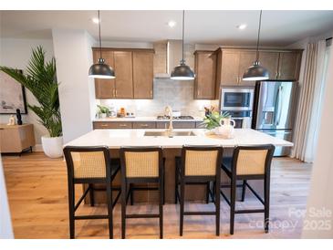 Bright eat-in kitchen featuring a large island with barstool seating and pendant lighting at 451 Old Town Village Rd, Waxhaw, NC 28173