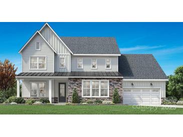 Charming two-story home with a stone and vinyl exterior, a welcoming front porch, and a two car garage at 5334 Mint Harbor Way # 0292, Charlotte, NC 28269