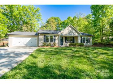 Charming single-Gathering home featuring a lush green lawn, a two-car garage, and a cozy front porch at 556 Westwood Dr, Kannapolis, NC 28081