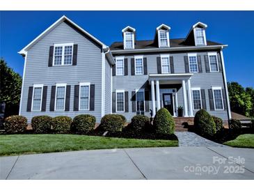 A beautiful gray two-story home with black shutters and well-manicured landscaping at 143 S Gibbs Rd, Mooresville, NC 28117