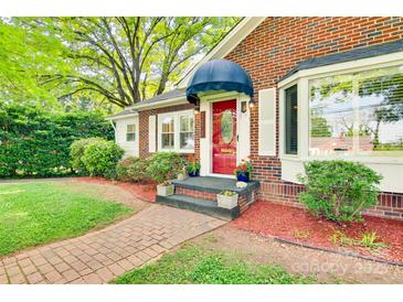 Charming brick home featuring a red front door with decorative glass, red mulch beds and a brick walkway at 1473 12Th Street Nw Dr, Hickory, NC 28601
