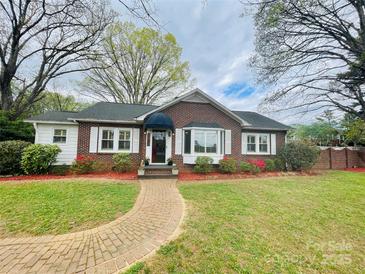 Charming brick home with a well-manicured lawn, brick walkway, and blossoming flowers, perfect for curb appeal at 1473 12Th Street Nw Dr, Hickory, NC 28601