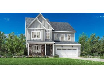 Charming two-story home featuring stone accents, gray siding, attached garage, and a well-manicured lawn at 4166 Eastover Glen Rd # 0327, Charlotte, NC 28269