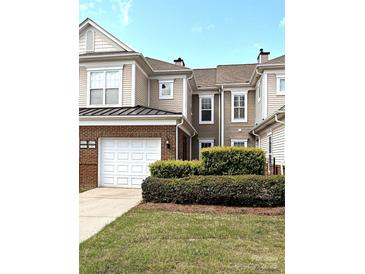 Charming townhome with a one-car garage and brick accents, surrounded by lush landscaping at 44429 Oriole Dr # 102, Indian Land, SC 29707