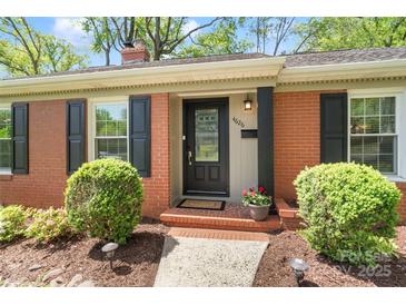 A cozy brick home entrance with black shutters and well-manicured landscaping at 4626 Fairbluff Pl, Charlotte, NC 28209