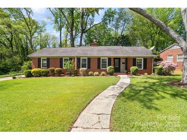 Charming brick home with a manicured front yard, walkway and mature trees at 4626 Fairbluff Pl, Charlotte, NC 28209
