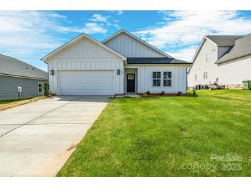 Charming single-story home with a well-manicured lawn and attached two-car garage at 540 Church St, Locust, NC 28097