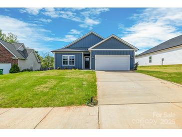 Charming single-story home featuring a two-car garage and well-maintained lawn at 544 Church St, Locust, NC 28097