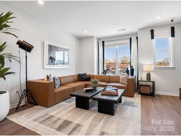 Modern living room with a brown leather sectional sofa and decorative accent furniture at 5516 Swaling St, Charlotte, NC 28217