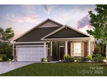 Charming single-Gathering home with a two-car garage, brick accents, and a well-manicured lawn at 562 Mountain View Dr, Monroe, NC 28110
