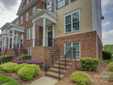 Brick and siding townhome featuring an inviting entrance, landscaped yard, and classic architectural details at 668 Sixth Baxter Xing, Fort Mill, SC 29708