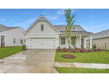 Charming single-Gathering home featuring a two-car garage, manicured lawn, and modern architectural details at 8432 Norman Forest Rd, Lancaster, SC 29720