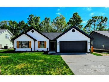 Charming single-story home featuring a black roof, wooden shutters, a two-car garage and a well-maintained green lawn at 8811 Steelechase Dr, Charlotte, NC 28273