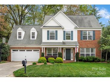 Charming two-story brick home featuring a well-manicured lawn and attached two car garage at 8929 Lizzie Ln, Huntersville, NC 28078