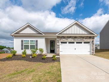 Charming single-Gathering home with stone accents, two-car garage, landscaping, and inviting curb appeal at 105 Tanner Loop, Troutman, NC 28166