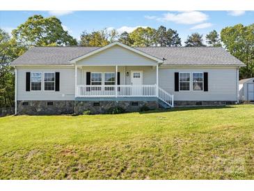 Attractive single-story home with stone foundation, lush lawn, and welcoming front porch at 1058 Canada Dr, Dallas, NC 28034