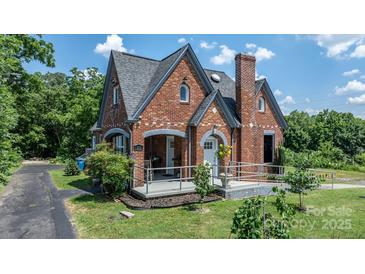 Charming brick home with unique architecture, lush landscaping, and a welcoming front porch at 115 12Th Sw St, Hickory, NC 28602