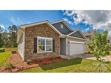 Charming home featuring stone accents, a two-car garage, and professional landscaping at 1328 Secrest Commons Dr, Monroe, NC 28112