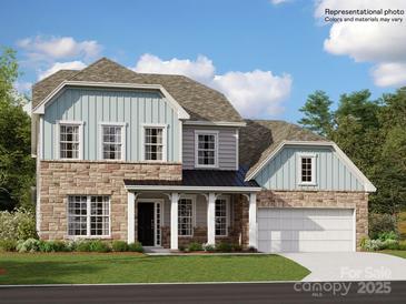 Charming two-story home with a stone and siding facade, covered porch, and an attached two-car garage at 1552 Croydon St, Indian Land, SC 29707
