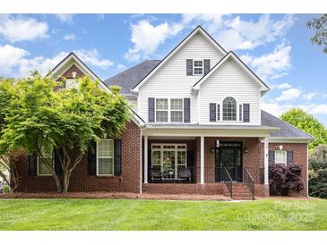 Charming two-story home with brick accents, covered porch, and well-manicured front yard at 212 Horn Tassel Ct, Indian Trail, NC 28079